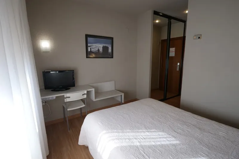 Habitación doble con zona de trabajo y televisión